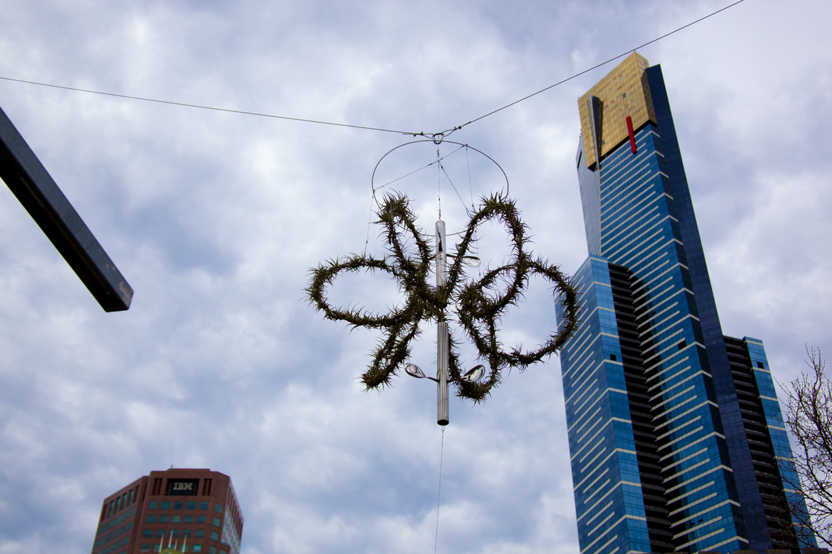 Alpha Space Station I, recycled stainless steel pipe, rice spoons, large gavanised spring, the three elements can rotate independently. Installed 27 July, 2013 - Images, with Melbourne's tallest building Eureka tower in the background. Lloyd Godman